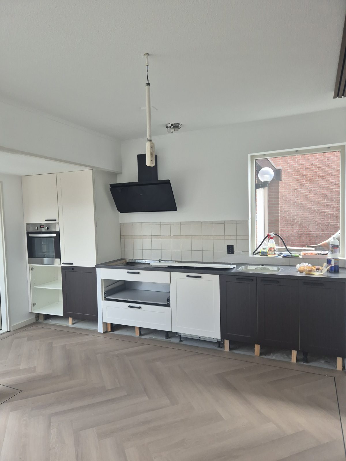 Keuken in Deventer tijdens het wrappen: links al donker Ebony Oak, in het midden nog de witte kaderfronten