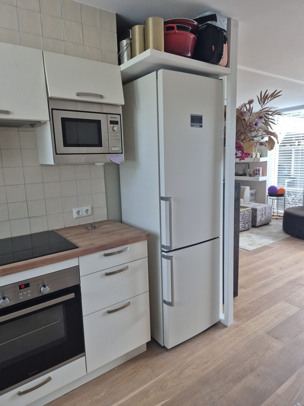 Dezelfde koelkast na het wrappen in Bodaq S263 White Structure, in de kleur van de keukenfronten