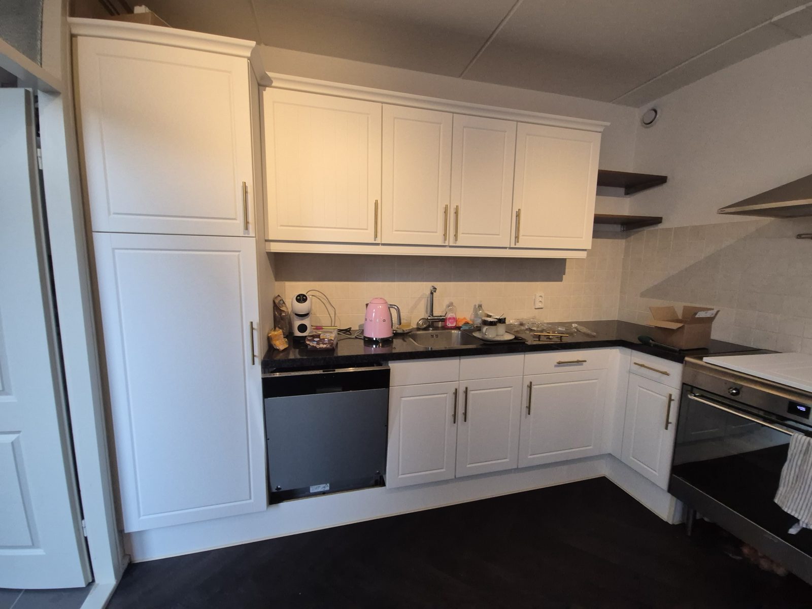 Dezelfde keuken na het wrappen in mat wit Bodaq S265 met messing grepen, Onstwedde